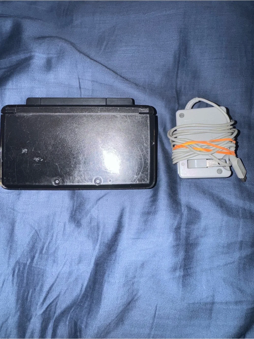 Black Nintendo 3ds with charger and cradle